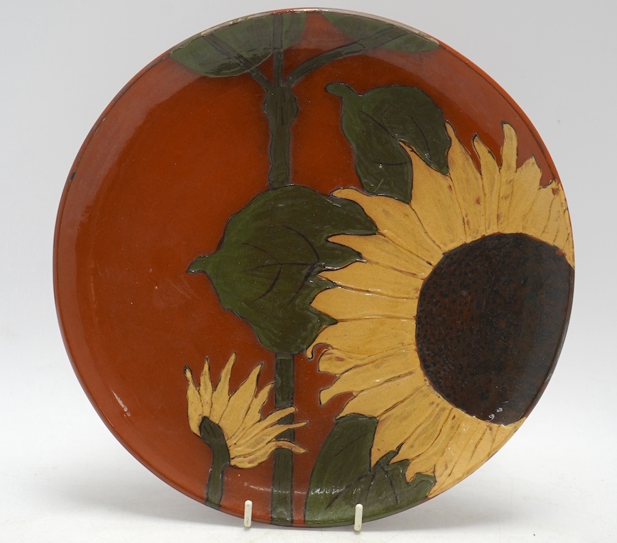 A late 19th century slipware Wedgwood wall plate, decorated with sunflowers, 25cm diameter. Condition - fair to good, some losses to the glaze on the rim